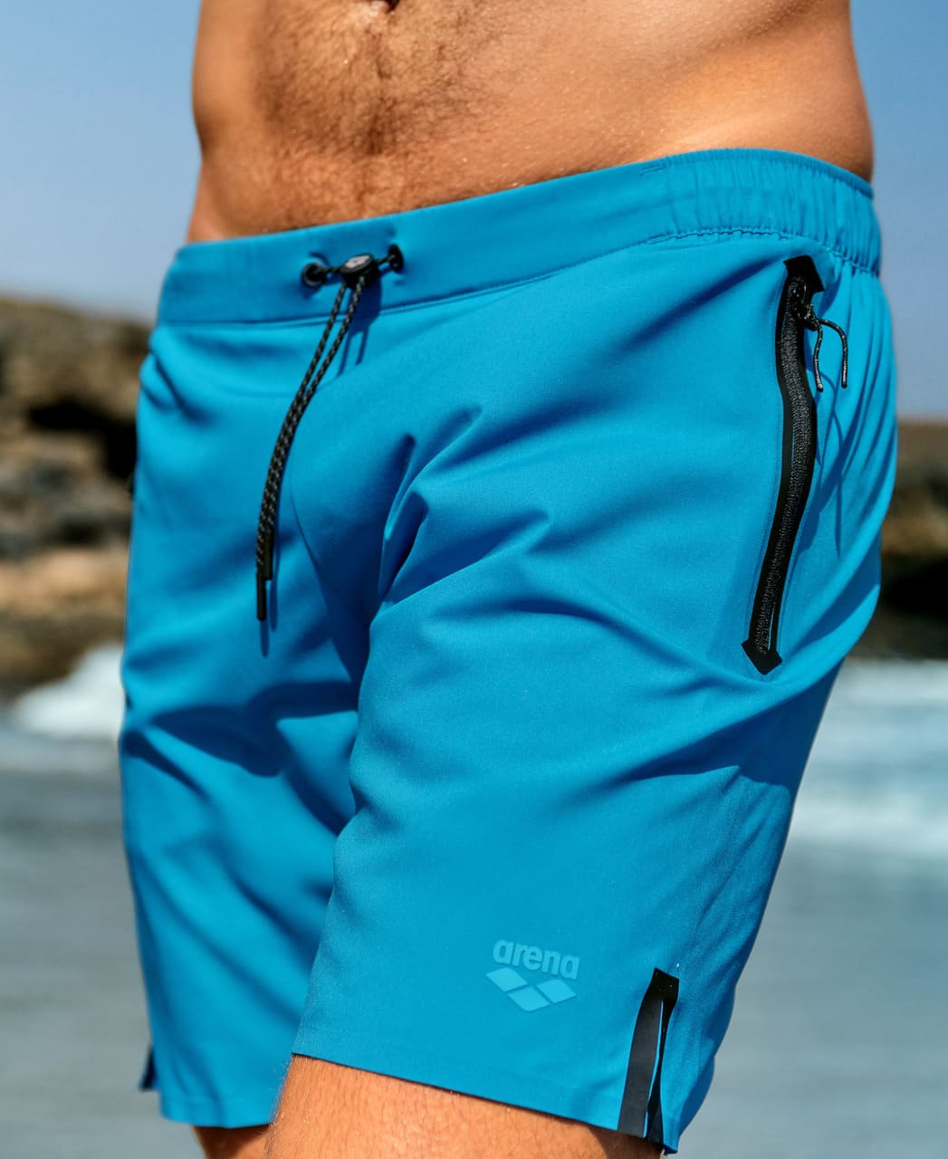 Nærmynd af túrkísbláum Arena Evo Side Zip Pockets Beach Boxer sundbuxum með reim með smellulás og renndum hliðarvasa.